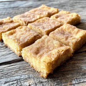 To make snickerdoodle blondies, you will need the following ingredients: - 1 cup unsalted butter, softened - 1 cup packed brown sugar - 1/2 cup granulated sugar - 2 large eggs - 2 teaspoons pure vanilla extract - 2 cups all-purpose flour - 1 teaspoon baking powder - 1/2 teaspoon baking soda - 1/2 teaspoon salt - 1 tablespoon ground cinnamon - Cinnamon sugar topping: 1/4 cup granulated sugar & 1 tablespoon ground cinnamon These ingredients create a rich, sweet base for the blondies. The butter and sugars provide a soft texture. The eggs add moisture and help the blondies rise. Flour gives structure, while baking powder and baking soda help with that perfect lift. Ground cinnamon brings warmth and flavor, making these treats feel cozy and comforting. The cinnamon sugar topping adds a sweet crunch to the top. This simple blend of sugar and cinnamon enhances the classic snickerdoodle flavor. With these ingredients, you are set to bake a delicious batch of snickerdoodle blondies. Each bite is soft, chewy, and full of flavor! - Preheat to 350°F (175°C). - Line a 9x13-inch baking pan with parchment paper. Start by preheating your oven to 350°F. This step is key. It sets the stage for even baking. Next, grab a 9x13-inch baking pan. Line it with parchment paper. Let the paper hang over the sides. This helps you lift out the blondies later. - Cream softened butter with brown sugar and granulated sugar. In a large bowl, add softened butter. Use an electric mixer to cream it with brown sugar and granulated sugar. Mix at medium speed for about 2-3 minutes. The mixture should be smooth and creamy. This step adds air, making the blondies soft. - Incorporate eggs one at a time. - Mix in vanilla extract. Now, it's time to add the eggs. Add one egg at a time, mixing well after each. This ensures a good blend. Next, pour in the vanilla extract. Mix until it's fully combined. The vanilla adds a lovely flavor. - Whisk together flour, baking powder, baking soda, salt, and cinnamon. In a separate bowl, combine your dry ingredients. Whisk together flour, baking powder, baking soda, salt, and ground cinnamon. Make sure everything is mixed well. This mix gives the blondies their structure and flavor. - Gradually add dry ingredients to wet mixture. Slowly add your dry mixture to the wet ingredients. Stir gently with a spatula. Be careful not to overmix. This keeps the blondies soft and chewy. You want just a few flour streaks left. - Spread batter in prepared pan and sprinkle cinnamon sugar topping. - Bake for 20-25 minutes. Next, spread the batter evenly in the prepared pan. Smooth the top with a spatula. In a small bowl, mix granulated sugar and ground cinnamon. Sprinkle this topping over the batter. Bake in the oven for 20-25 minutes. The edges should be golden, and a toothpick should come out with moist crumbs. - Cool on wire rack and slice into squares. Once baked, take the pan out of the oven. Let it cool on a wire rack for about 20 minutes. Use the parchment paper to lift the blondies out. Set them on the rack to cool completely. When cool, slice into squares. Enjoy these delicious, soft, and chewy treats! To make snickerdoodle blondies soft and chewy, do not overmix the batter. Overmixing can make the blondies tough. Mix just until you see no dry flour. Also, use room temperature ingredients. This helps them blend smoothly and creates a better texture. For the best flavor, use fresh spices. Fresh ground cinnamon adds a warm aroma. You can also try add-ins like nuts or chocolate chips. These can enhance the taste and make each bite even more fun. When serving, arrange the blondies on a tiered cake stand or a colorful platter. This makes them look more appealing. Before serving, dust the top with extra cinnamon sugar. It adds a nice touch and makes them look fancy. {{image_4}} You can change the classic blondie by adding cocoa powder. Use about 1/3 cup of cocoa powder and mix it in with the dry ingredients. This gives a rich chocolate flavor. To make it even better, add 1 cup of chocolate chips. The chips melt and create gooey pockets of chocolate in every bite. If you want a crunch, try nuts! Walnuts or pecans work great. Chop about 1 cup of nuts and fold them into the batter. This adds a lovely texture and flavor. The nuts complement the cinnamon and sugar perfectly, making each bite exciting. For a gluten-free take, swap regular flour for gluten-free flour. You can use a blend that works well for baking. Make sure it has a good structure to keep the blondies soft and chewy. This way, everyone can enjoy these treats without worry! To keep your snickerdoodle blondies fresh, store them in an airtight container. This helps prevent them from drying out. You can keep them at room temperature for up to four days. If your kitchen is warm, it’s best to store them in the fridge. This keeps them moist and chewy. If you want to save some blondies for later, freezing is a great option. First, let the blondies cool completely. Then, wrap them tightly in plastic wrap. After that, place them in a freezer-safe bag or container. They can last in the freezer for up to three months. When you’re ready to enjoy them, just thaw them at room temperature. To enjoy leftover blondies, you can reheat them in the microwave. Heat them for about 10-15 seconds. This warms them up and makes them soft again. If you prefer a crispy edge, you can warm them in the oven at 350°F for 5-10 minutes. Enjoy that fresh-baked taste all over again! Snickerdoodle blondies are a soft and chewy dessert. They blend classic snickerdoodle flavors with a blondie base. You get the sweet taste of brown sugar and cinnamon in every bite. The buttery texture makes them rich and satisfying. These treats are great for sharing or enjoying alone. To check if the blondies are done, look for a few signs: - The edges should be lightly golden. - A toothpick inserted in the center should come out with a few moist crumbs. - The top should look set and not shiny. Bake them for 20-25 minutes for the best results. If you follow these cues, you will have perfectly baked blondies. Yes, you can use different types of sugar. Each type will change the flavor and texture: - White sugar gives a lighter flavor. - Brown sugar adds moisture and depth. - Coconut sugar offers a caramel taste. Experiment with what you have to find your favorite blend. If you want a vegan version, you can use several egg substitutes: - 1/4 cup applesauce for each egg. - 1/4 cup mashed banana for each egg. - 2 tablespoons ground flaxseed mixed with 6 tablespoons water can also work well. These options will help keep the blondies soft and tasty without eggs. In this guide, I shared a simple recipe for Snickerdoodle Blondies. You learned about the key ingredients, step-by-step instructions, and helpful tips. I also covered variations like chocolate and nutty versions and offered storage advice to keep your blondies fresh. These blondies are delicious, easy to make, and perfect for sharing. Enjoy baking and experimenting with flavors to find your favorite!